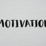 Inspirational word 'Motivation' in black on a white textured canvas background.