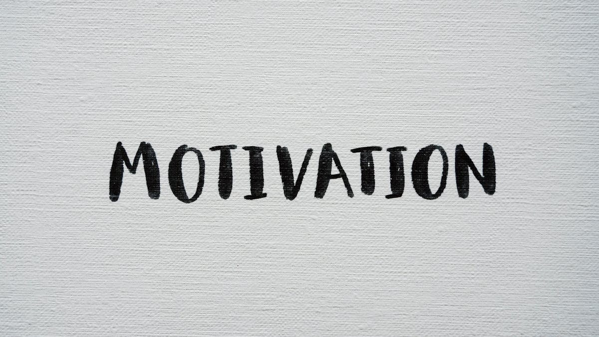 Inspirational word 'Motivation' in black on a white textured canvas background.